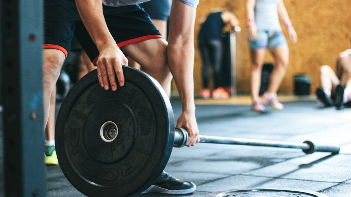 Focused weightlifting session in a gym with diverse athletes participating indoors.